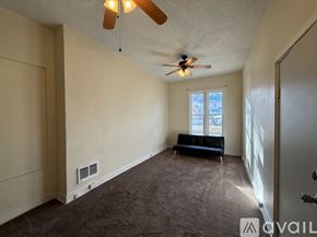 Raton apartment for rent - A room with a ceiling fan and a window with blinds.