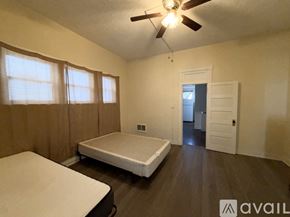 Raton apartment for rent - A bedroom with a bed, a ceiling fan, and a door leading to another room.