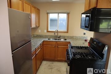 Eagan apartment for rent - A kitchen with a black stove top oven and a black microwave above it.