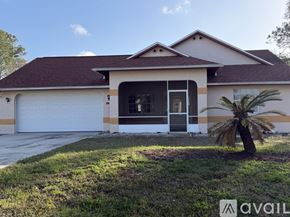Palm Coast house for rent - A white house with a brown roof and a palm tree in front.