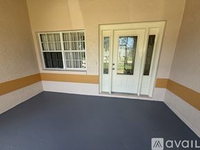 Palm Coast house for rent - A spacious room with tiled flooring and a glass door leading to another room.