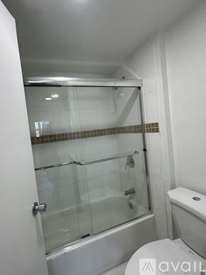 Miami apartment for rent - A bathroom with a glass shower door and a toilet.