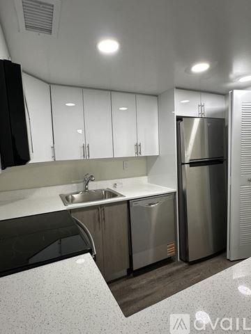 Miami apartment for rent - A modern kitchen with stainless steel appliances and white cabinets.