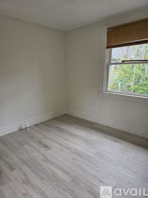 Rochester apartment for rent - A room with a window and wooden flooring.