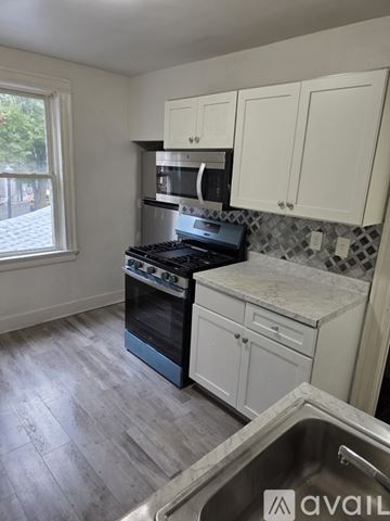 Rochester apartment for rent - A kitchen with a stove top oven and a microwave above the stove.
