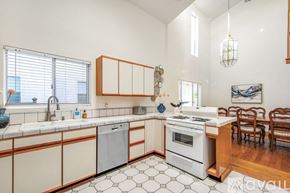 Dana Point house for rent - A kitchen with white cabinets and a white stove top oven.