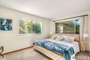 Dana Point house for rent - A bedroom with a large bed and a painting on the wall.