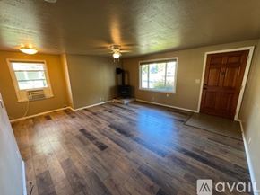 Ellensburg house for rent - A room with wooden flooring and a ceiling fan.
