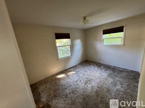 Ellensburg house for rent - A room with a carpeted floor and two windows.