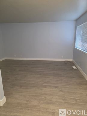 Roseville apartment for rent - A room with wooden flooring and a window with blinds.