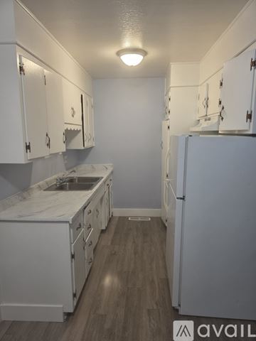Roseville apartment for rent - A kitchen with white cabinets and a white fridge.