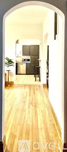 Kingsport house for rent - A hallway with wooden floors and a white archway leading to a kitchen.