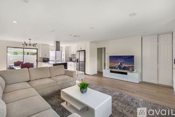 Aliso Viejo house for rent - A modern living room with a large sectional sofa and a flat-screen TV.