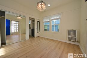 Los Angeles apartment for rent - A room with wooden floors and white walls, with a sliding glass door and a window.