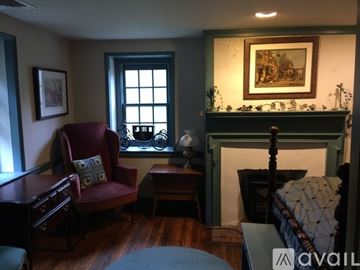 Media house for rent - A living room with a red chair and a fireplace.