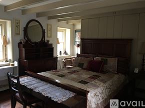 Media house for rent - A bedroom with a large bed and a wooden dresser.