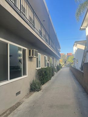 Valley Village apartment for rent - A long, narrow street with a row of houses on one side and a clear blue sky above.