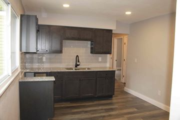 St. Louis house for rent - A kitchen with dark wood cabinets and a white countertop.