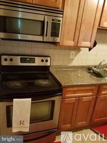 District Heights apartment for rent - A kitchen with a stove top oven and microwave above it.
