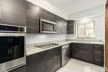 Columbus townhouse for rent - A kitchen with dark wood cabinets and stainless steel appliances.