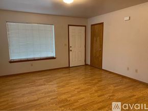 College Place apartment for rent - A room with wooden floors and a white door.