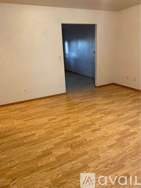College Place apartment for rent - A room with wooden flooring and a doorway leading to another room.