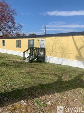 Zebulon apartment for rent - A yellow building with a green door and a black railing.