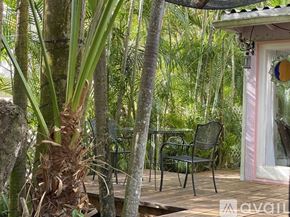 Miami apartment for rent - A patio with a table and chairs surrounded by trees.
