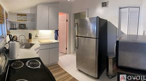 Miami apartment for rent - A kitchen with a black stove top oven and a large stainless steel refrigerator.