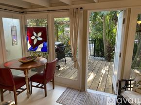 Miami apartment for rent - A table with chairs and a stained glass window in a room.