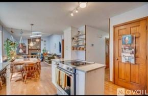 Stafford house for rent - A kitchen with a wooden table and chairs, a stove, and a refrigerator.