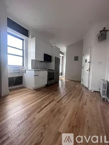 New York apartment for rent - A spacious room with wooden flooring and white walls.