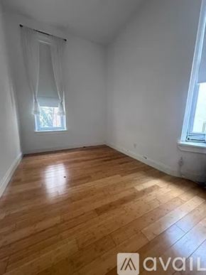 New York apartment for rent - A room with wooden flooring and a window with white curtains.