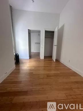 New York apartment for rent - A room with wooden floors and white walls, with a door in the background.