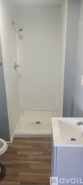 Dublin apartment for rent - A white bathroom with a wooden floor and a white sink.