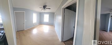 Dublin apartment for rent - A spacious room with a ceiling fan and wooden flooring.