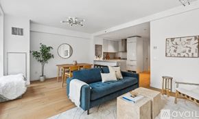 New York apartment for rent - A living room with a blue couch and a white rug.