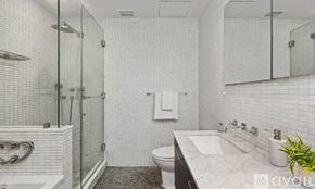 New York apartment for rent - A bathroom with a white tiled shower and a glass door.