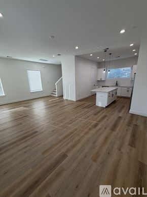 Houston house for rent - A spacious room with wooden flooring and white walls.