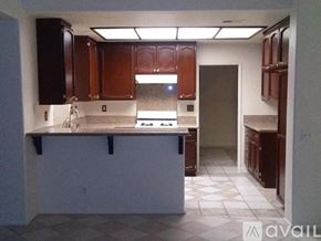 Palmdale house for rent - A pool surrounded by a wooden fence and trees.