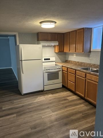 Peoria apartment for rent - A kitchen with a white refrigerator and wooden cabinets.