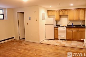 Boston apartment for rent - A kitchen with wooden cabinets and a white fridge.
