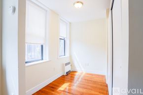 Boston apartment for rent - A room with a wood floor and a window with blinds.