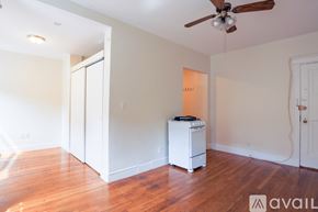 Boston apartment for rent - A room with a white fridge and a ceiling fan.