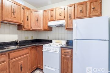Boston apartment for rent - A kitchen with wooden cabinets and a white refrigerator.