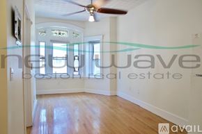 Boston apartment for rent - A room with a ceiling fan and a window with a view of the ocean.