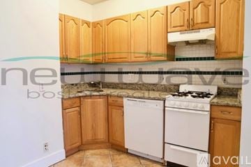 Boston apartment for rent - A kitchen with wooden cabinets and a white stove top oven.