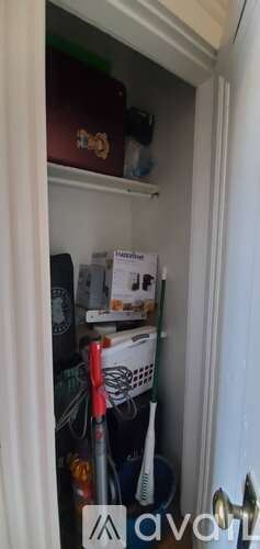 Boston apartment for rent - A small, dark brown box with a gold emblem is on the top shelf of a white cabinet.