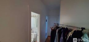 Boston apartment for rent - A row of clothes hanging on a rack in a room.