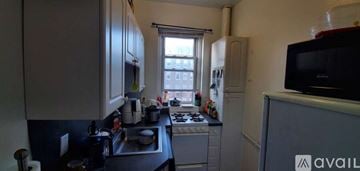 Boston apartment for rent - A kitchen with a black counter top and white cabinets.